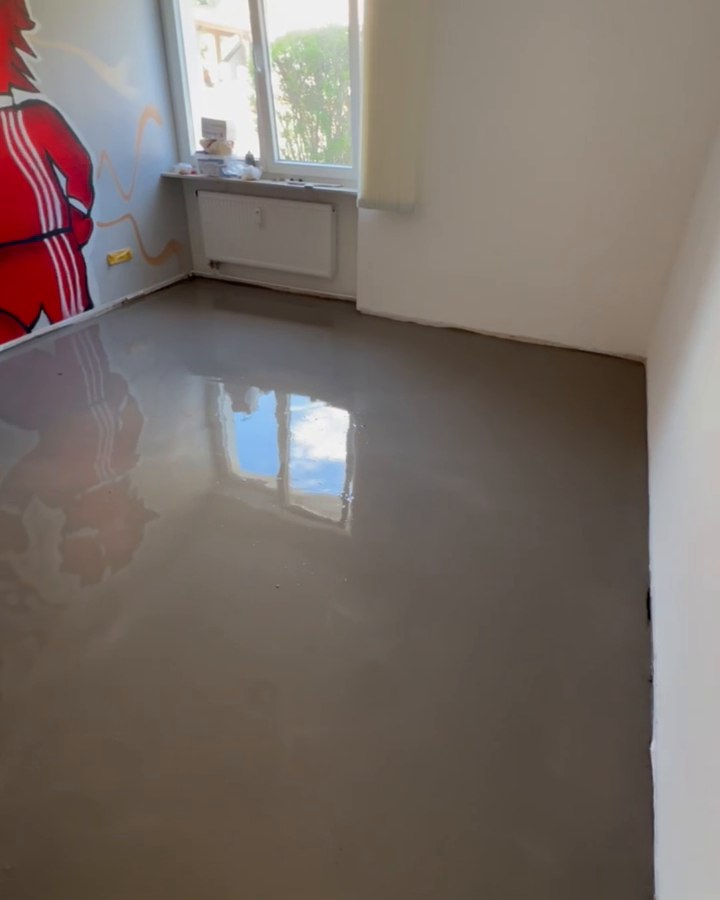 Frisch ausgeglichene Bodenfläche mit Spiegelung des Fensters.